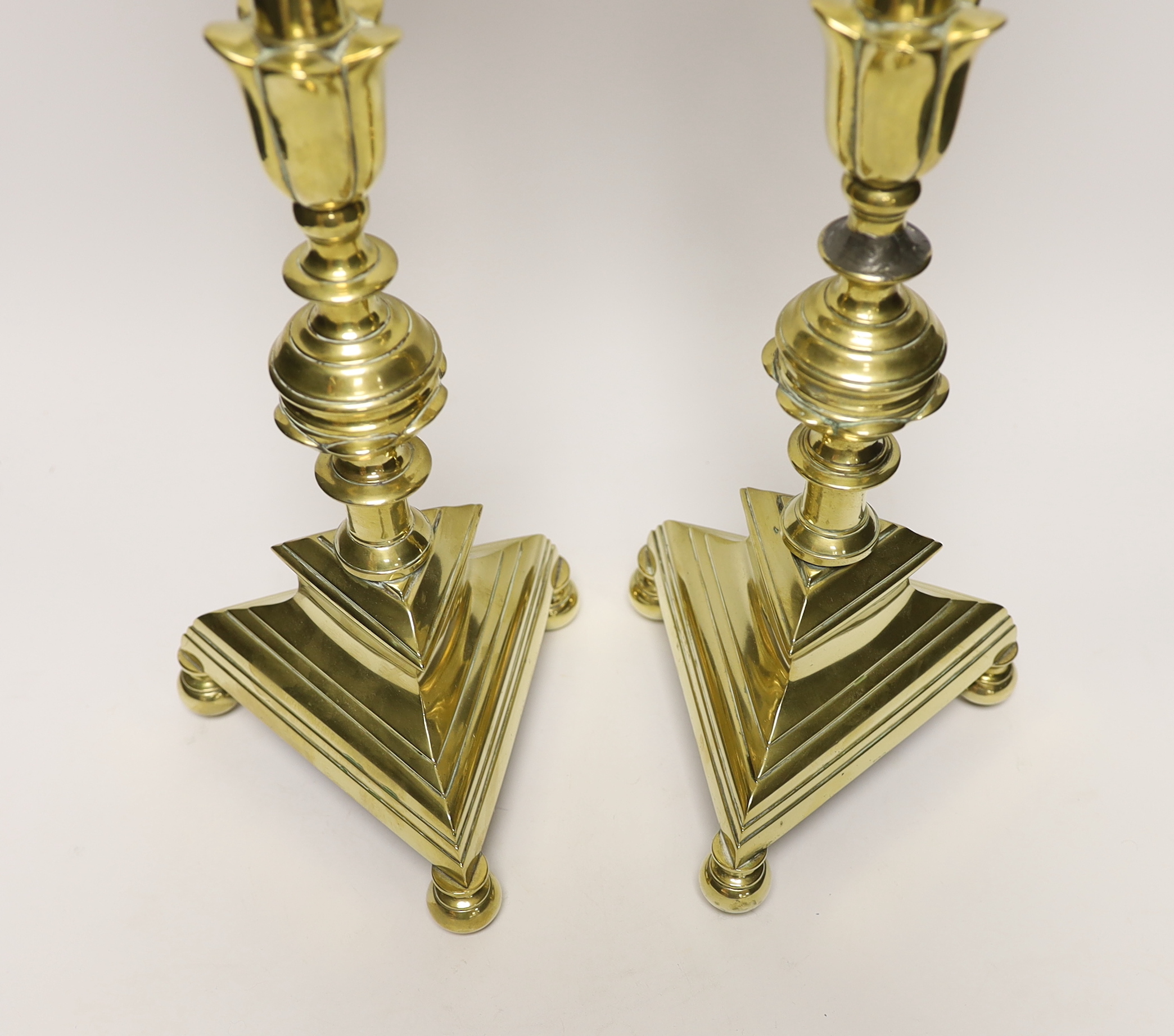 A pair of 17th Century Dutch brass pricket candlesticks, 58cm high